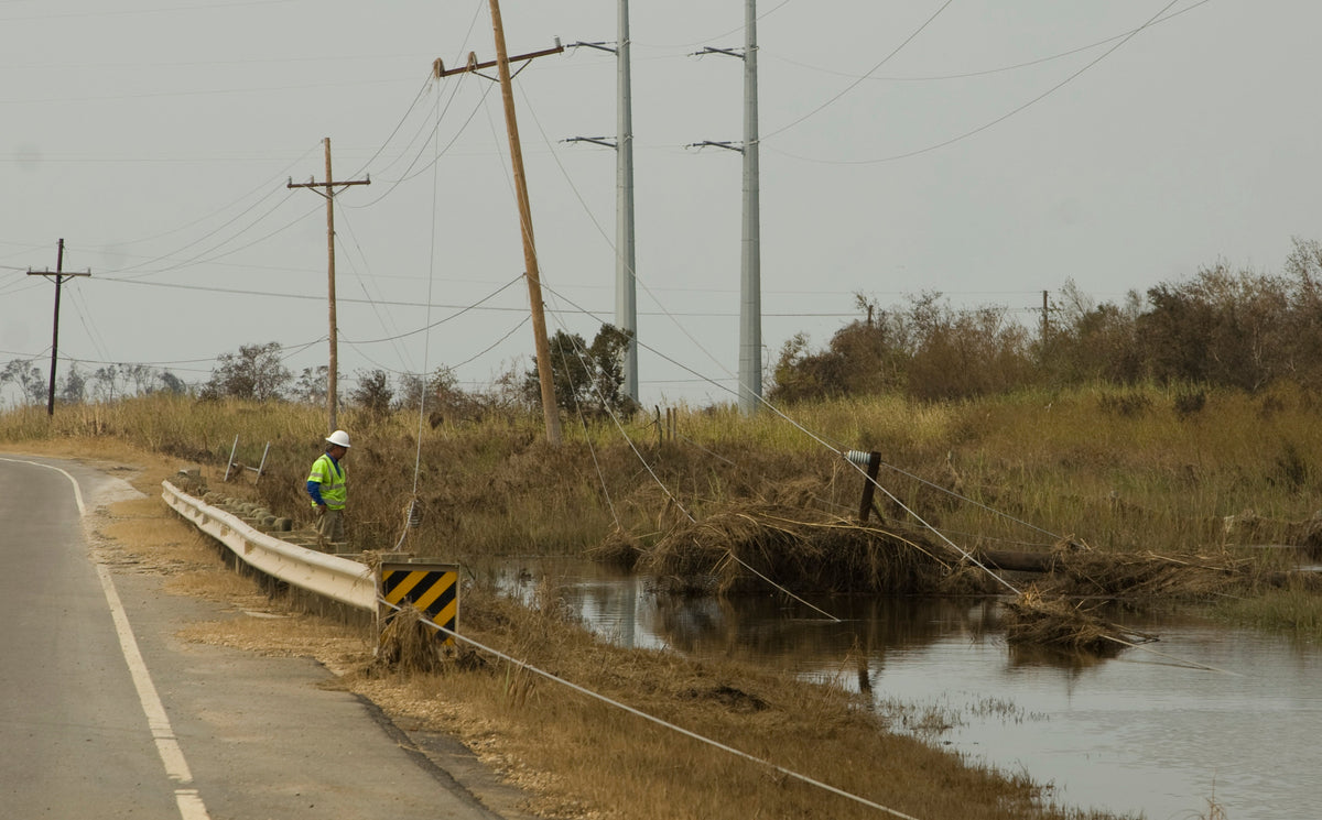 Lineman inspecting a damaged power line after a storm