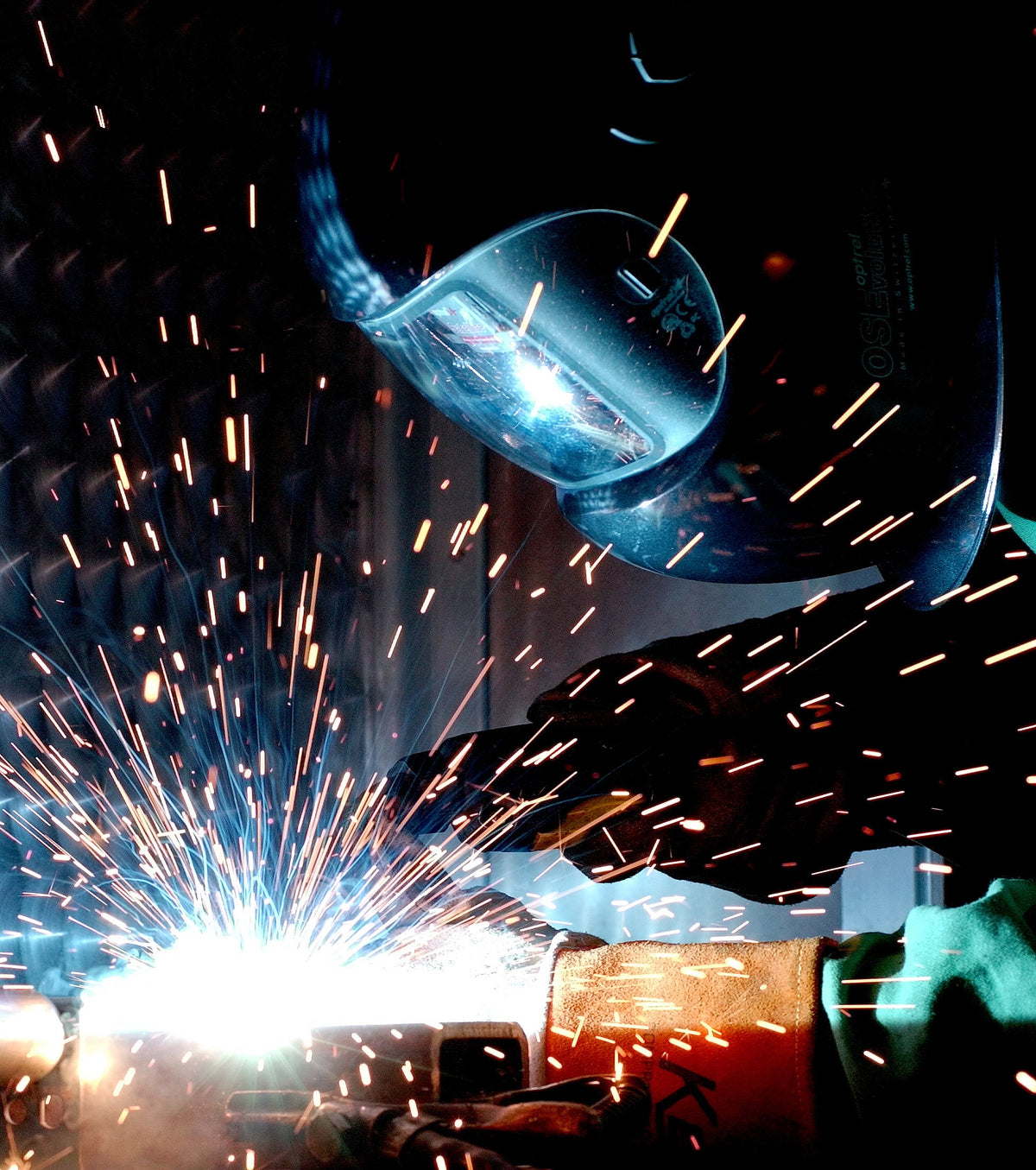 Welder performing gas metal arc welding with protective helmet